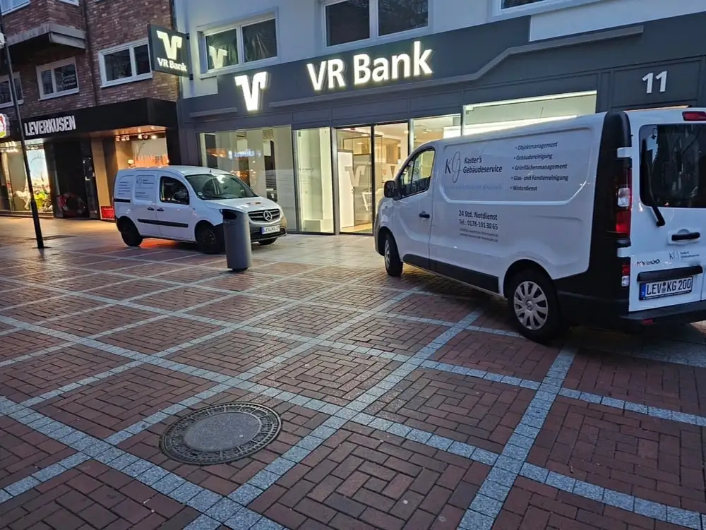 Fahrzeuge von Kaster’s Gebäudeservice vor der VR Bank