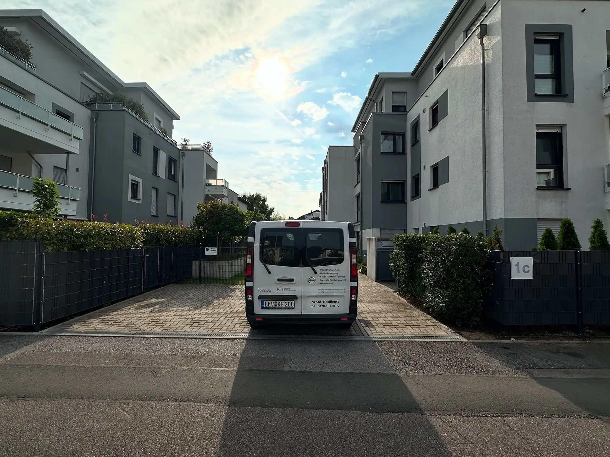 Fahrzeug von Kaster’s Gebäudeservice in der Zufahrt einer Wohnanlage